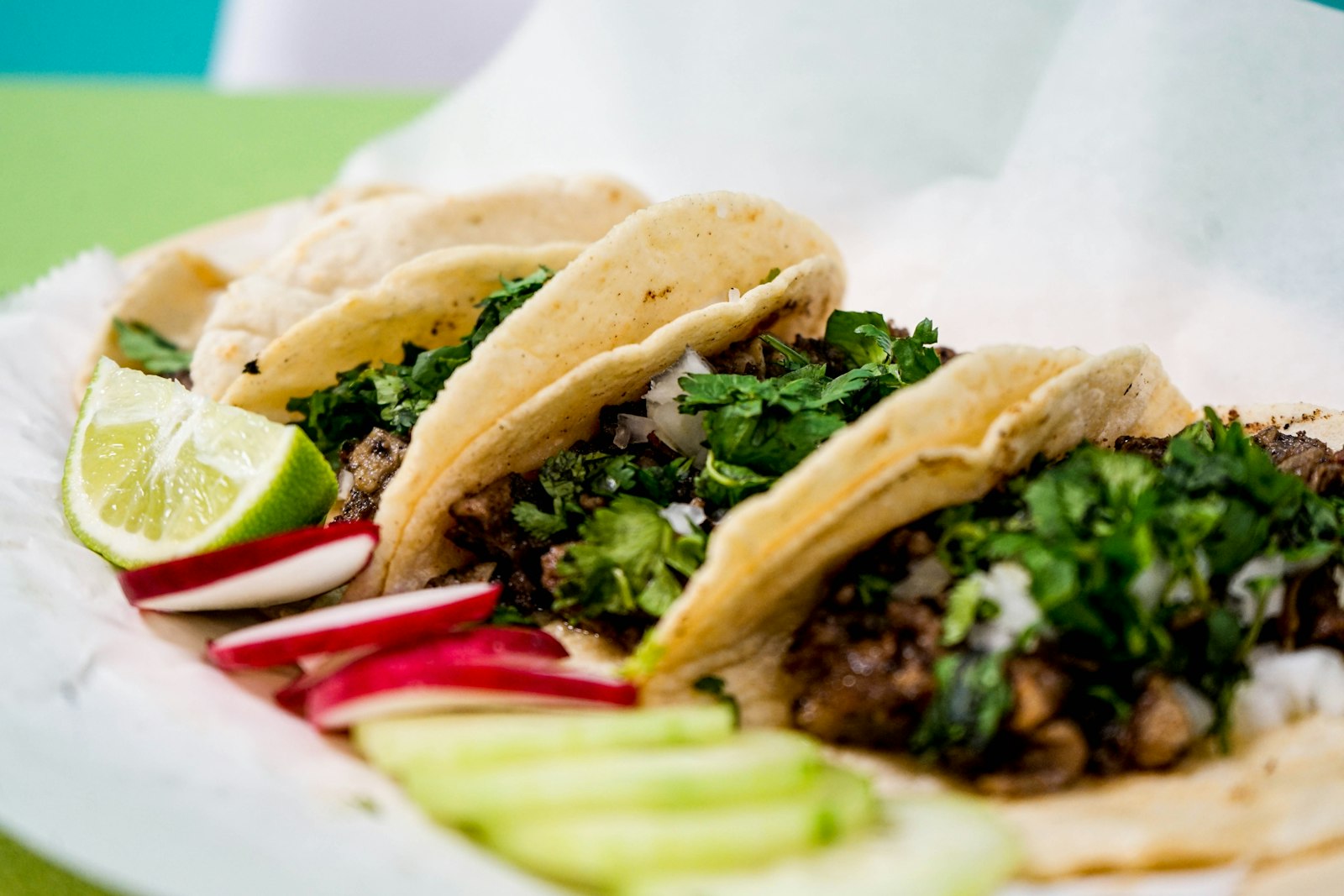Tacos callejeros en tortilla de maíz con cilantro, limón y rábano, imagen representativa